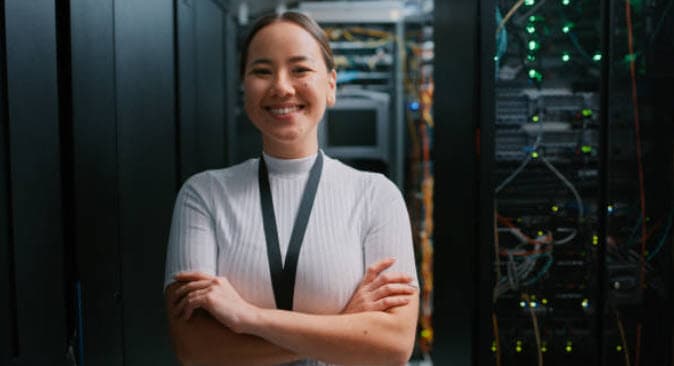 IT professional standing beside server racks